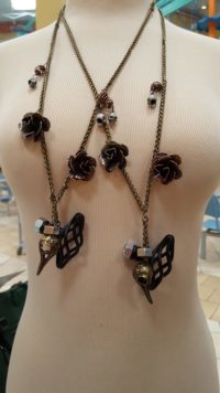 A close-up of a multi-pendant necklace hanging on a mannequin.