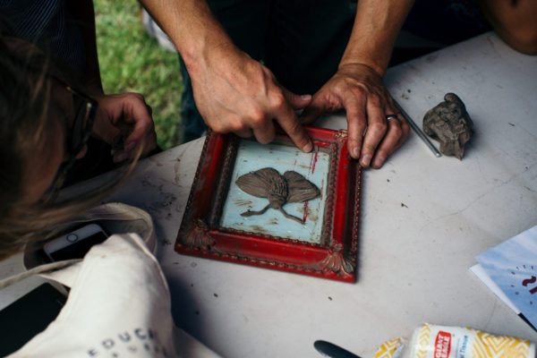 artseducationleadershipacademycarriefurnacenicosegalltobon-12_44595336051_o A closeup of an artists hands as they work on creating a butterfly-shaped metal casting mold.