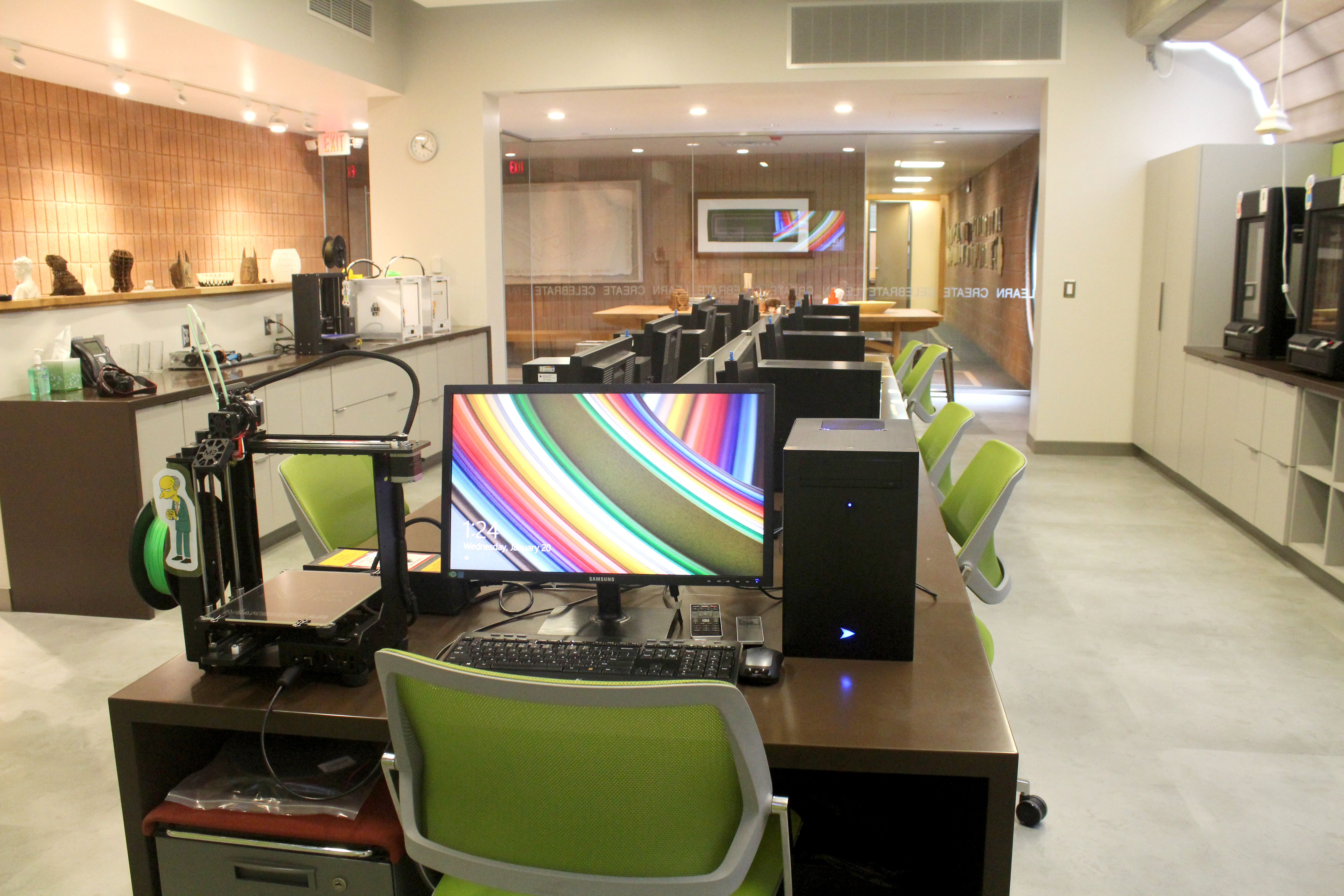 The image is of MCG Youth & Arts Tech Suite. There are computer stations and 3D technology.