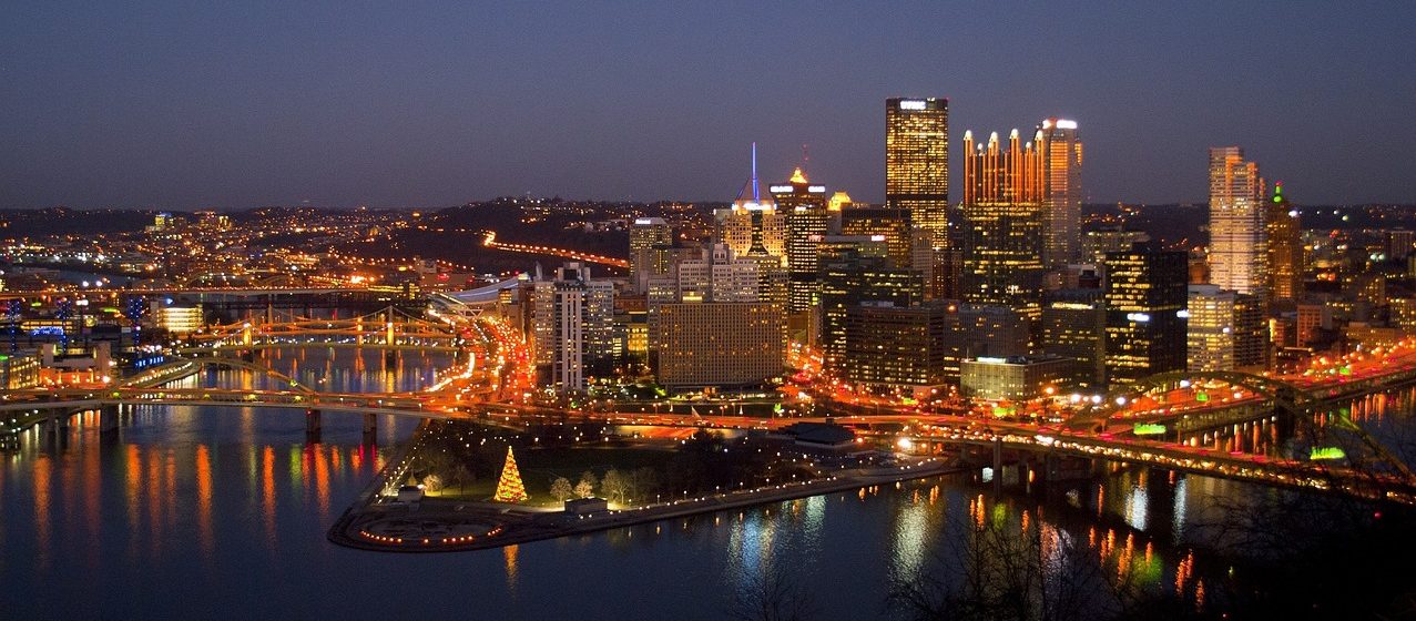 The image depicts the Pittsburgh skyline at night