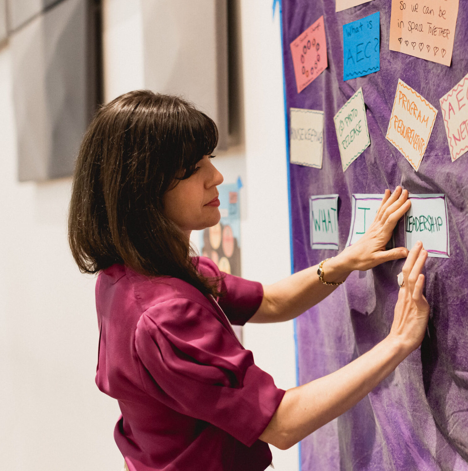 Yael posting cards on sticky wall