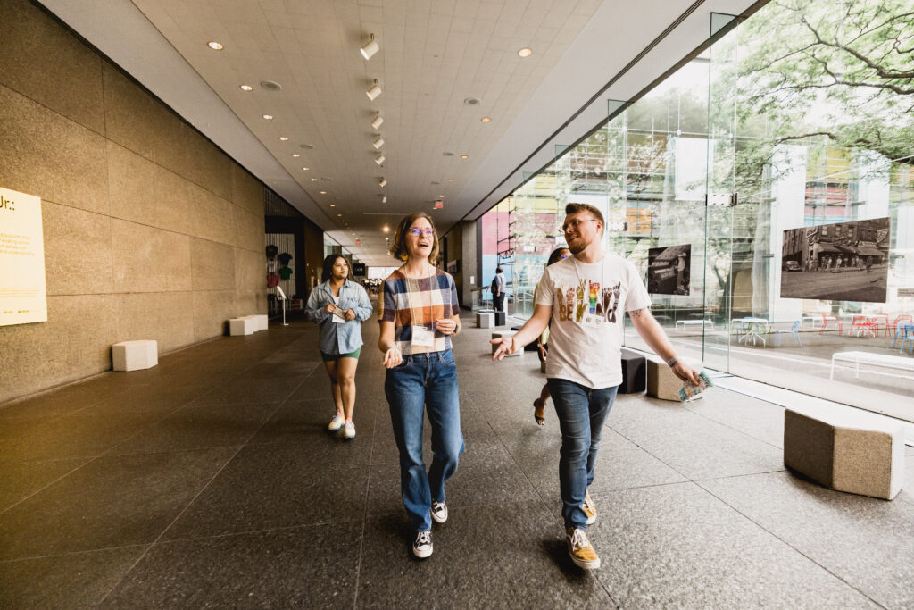 Two people walk towards the camera, another group walks behind them.