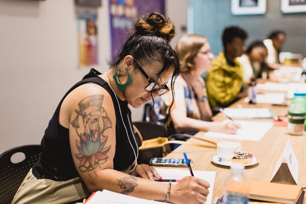 Woman in front of frame writes on a piece of paper