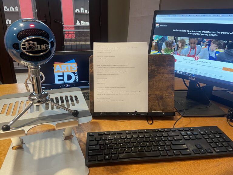Microphone sits on desk with AEC logo behind it.