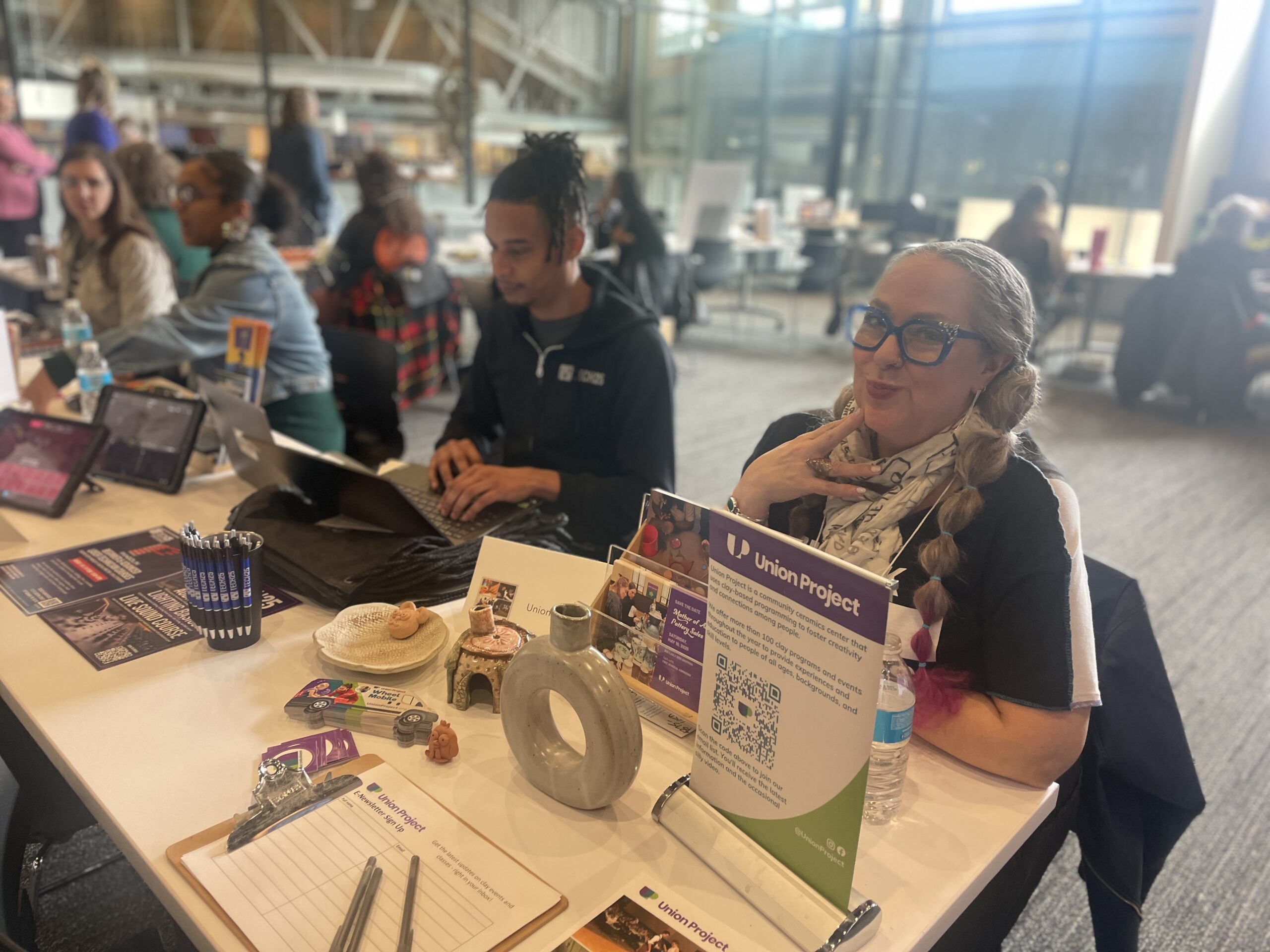 Group of people sit and smile at a table at the Arts Partner Fair.